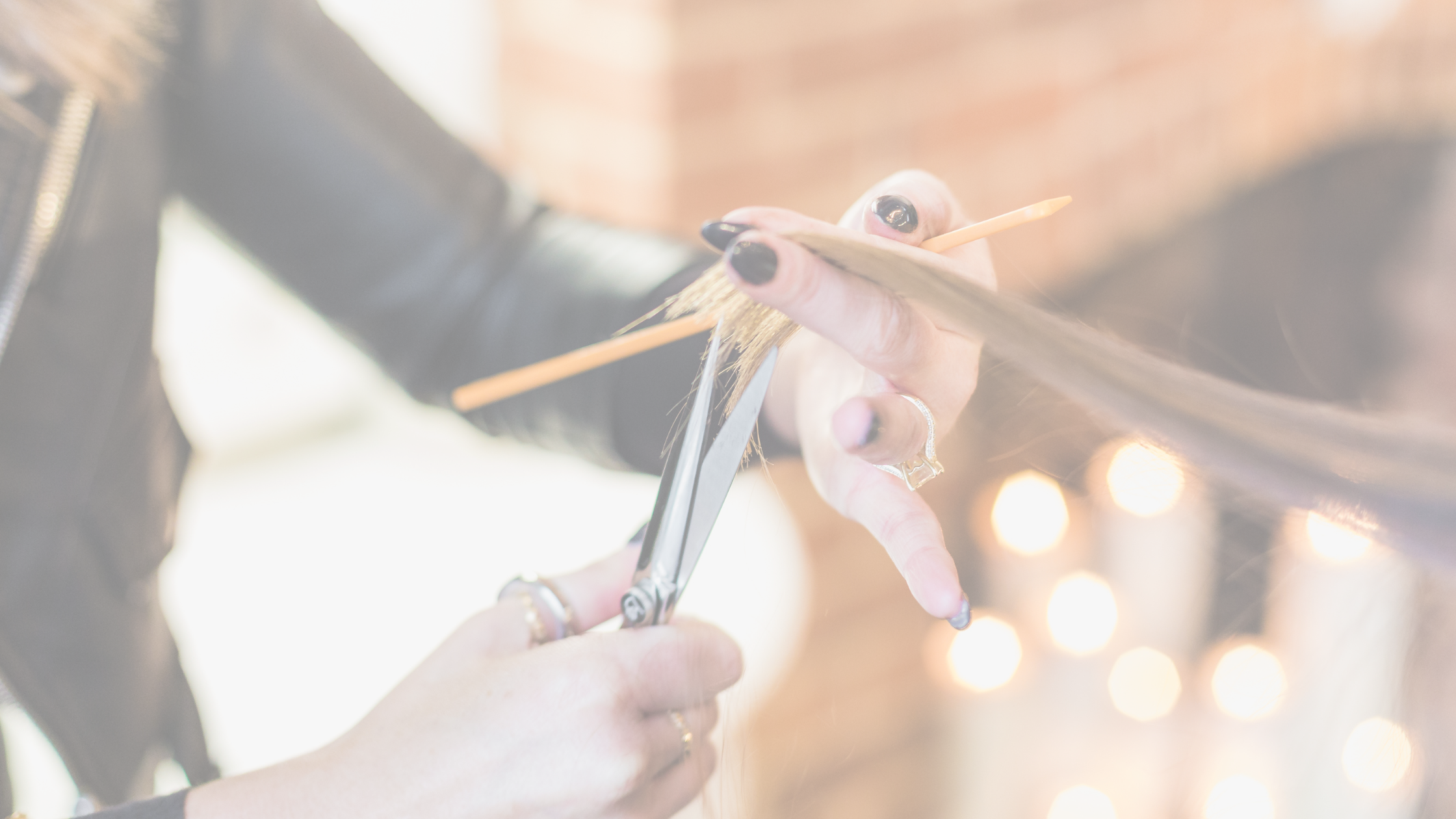 Close up of stylist cutting hair at Luxe Beauty Company.